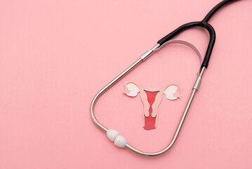 Medical Stethoscope Framing a Female uterus cutout on Pastel Pink Background, women's reproductive health and fertility