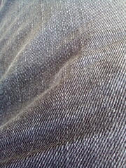 Gray denim fabric surface background. The photo was taken on a mobile phone.