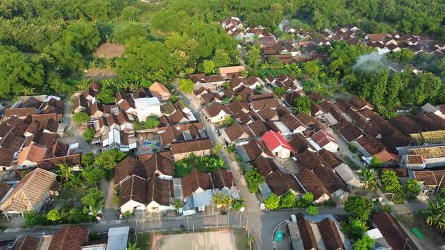 Aerial view small beautiful village in Indonesia. Terbang di atas rumah dan jalanan sebuah desa kecil di Indonesia menggunakan drone. 4k drone footage