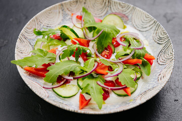 Fresh vegetable salad with arugula, cucumbers, tomatoes, and red onions - healthy food projects