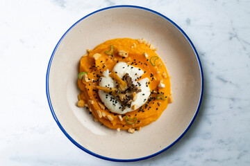 Sweet potato cream with poached egg and mushrooms. Top view table.