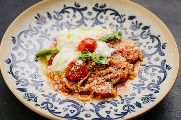 Italian pasta with cherry tomatoes, burrata, and fresh basil - gourmet dish for food lovers