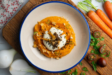 Sweet potato cream with poached egg and mushrooms. Top view table.