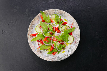 Colorful fresh salad with arugula, cucumbers, and tomatoes - a perfect dish for healthy eating 
