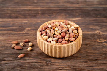 Roasted mixed nuts in the bowl on the wooden table 