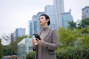 Young Professional in Urban Landscape with Coffee and Smartphone