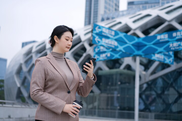 Fototapeta premium Confident Businesswoman Engaged with Mobile Device in Urban Setting