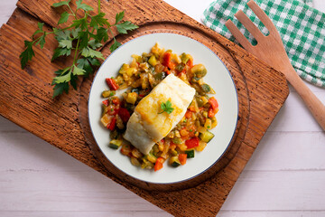 Cod with baked vegetables traditional Spanish recipe. Top view food.