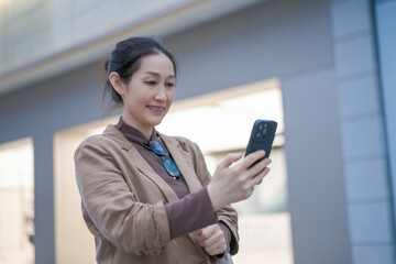 Obraz premium Young Woman Engaged with Smartphone in Urban Environment