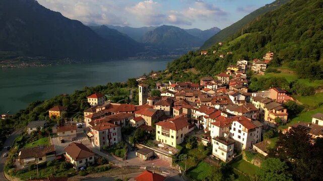 Claino con Osteno hilltop borgo, cinematic drone pullback reveal at sunset Lago di Lugano Lombardia Italy 4K establishing shot. Italian Alps landscape. B-roll for travel documentary, copy space sky