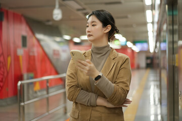 Confident Woman in a Stylish Outfit Waiting at a Subway Station
