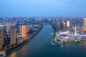 Obraz premium Vibrant Cityscape at Dusk - Aerial View Over Urban River