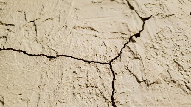 Cracks on cement, plastered surface, wall. Cracked plaster, concrete wall, close-up