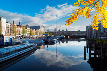 Moored boats and facades of old historic Houses over canal water, Amsterdam, Netherlands