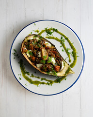 Eggplant stuffed with tomato and baked mozzarella. Top view food table.