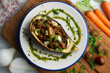 Eggplant stuffed with tomato and baked mozzarella. Top view food table.