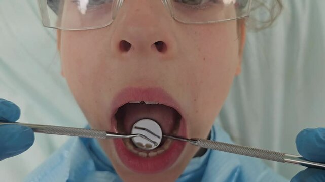 Girl patient whose teeth are being checked dentist. Dental treatment, children dentistry.