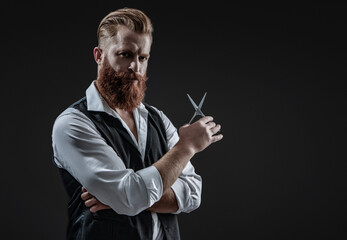 Hairstylist serving at barber shop. Barbershop. Man with red beard. Hairstylist at barber shop isolated on black. Barber using scissors. Brutal hairdresser cutting hair. Copy space advertisement