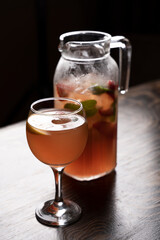 Cocktail in a glass with ice and mint on a wooden table