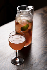 Cocktail in a glass with ice and mint on a wooden table