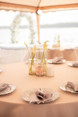 Wedding banquet concept. Chairs and a round table for guests, set with cutlery, flowers and dishes, covered with a tablecloth. Vases with calla lilies (6)