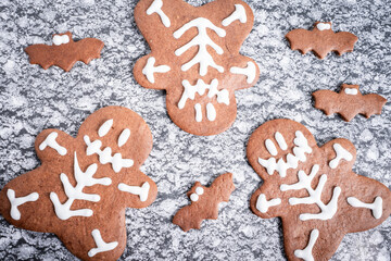 Halloween chocolate cookies, shaped and decorated in a Halloween theme. On a grey background.