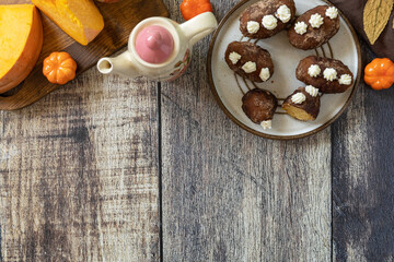 Chocolate rum potato cake with pumpkin on rustic background, homemade vegan dessert. Traditional Eastern European dish with cocoa and butter. Chocolate sweets filled with marzipan. Copy space.