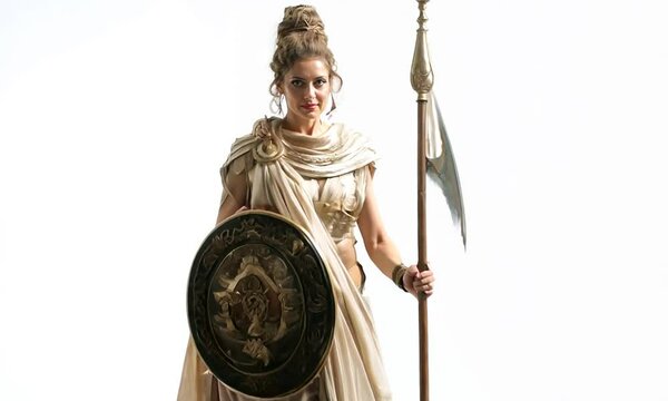A woman in a white costume holding a shield and a spear