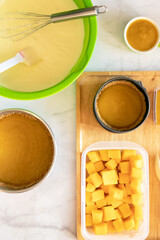 Delicious ingredients for baking, featuring batter, puree, and fresh cubed fruit ready for a tasty dessert preparation.