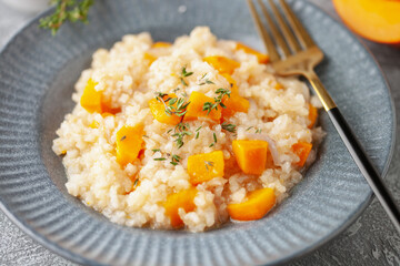 Pumpkin risotto with fresh thyme in plate. Italian Food