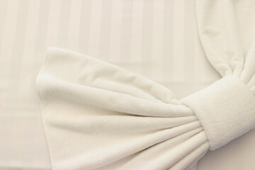 Elegant white fabric with a soft bow, perfect for wedding decorations or interior design inspirations.