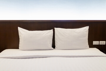 Cozy bedroom with two crisp white pillows on a neatly made bed.