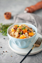 Pumpkin mushrooms risotto with fresh thyme in ceramic bowl. Italian Cuisine.