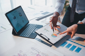 Business people analyzing financial charts and graphs on a desk