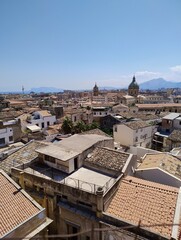 View over the historical centre of Palermo city. Old architecture with a dome. Cathedrals. Churches. Rooftops of italian buildings. Sicily history. Life in Italy. Clear blue sky in summer. Hills.