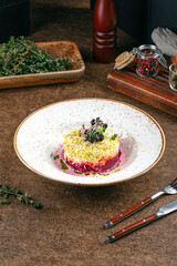 Portion of gourmet herring layered salad with beetroot