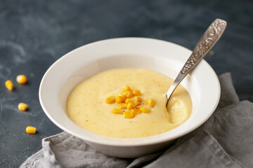Delicious creamy corn soup in ceramic bowl on the table. Vegetarian food