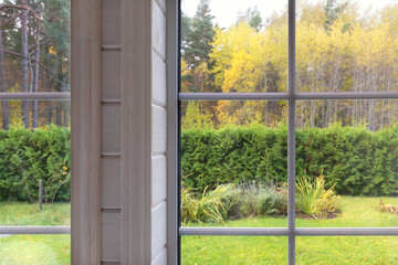 Cozy homely atmosphere. Knitted pumpkins and a warm scarf on the window. Autumn mood. Autumn outside the window