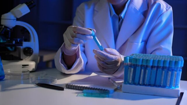 Scientist analyzing sample in test tube in laboratory
