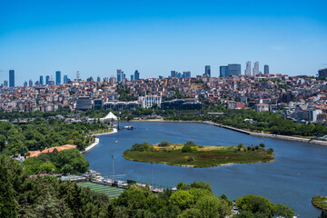 Türkiye. Istanbul. Panoramic view of the Golden Horn with its green banks, buildings and skyscrapers in the background under a sunny blue sky