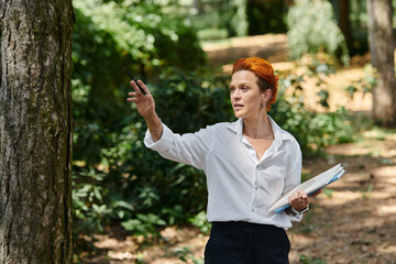 Fiery red-haired teacher energetically points and explains to students outdoors