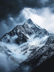 Obraz premium Majestic Snowy Mountain Peaks with Dramatic Cloud Formation and Open Sky Above