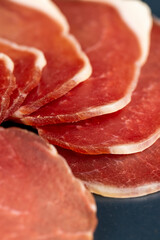 sliced ham with bacon on a board