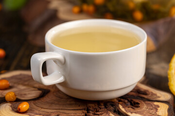 tea with orange and ripe sea buckthorn berries