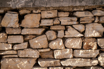 Close-up of a stone wall texture without cement, showcasing rough, uneven stones stacked together, perfect for backgrounds, architecture, or rustic designs.
