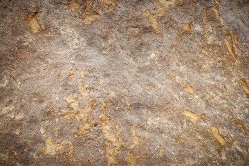 Brown grey rough stone wall with surface orange rusted for abstract background and texture, interior or exterior design. Beautiful patterns, space for work, banner, wallpaper. Close up.