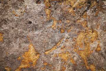 Brown grey rough stone wall with surface orange rusted for abstract background and texture, interior or exterior design. Beautiful patterns, space for work, banner, close up.