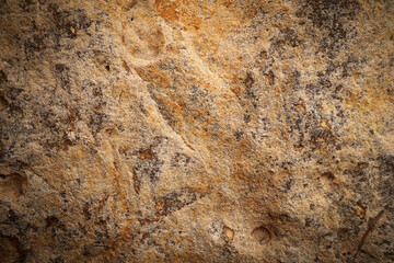 Brown grey rough stone wall with surface orange rusted for abstract background and texture, interior or exterior design. Beautiful patterns, space for work, banner, wallpaper, close up.