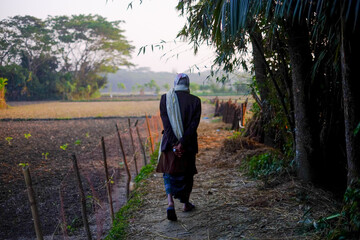 Elderly person walking through a village road
