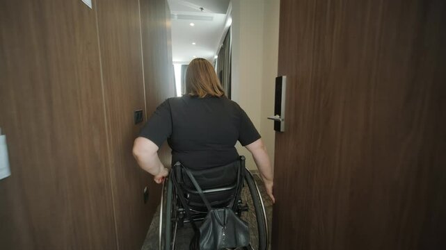 A woman in a wheelchair navigates through a hotel room, highlighting accessible accommodations and inclusive design. The image emphasizes mobility, independence, and modern hospitality infrastructure.